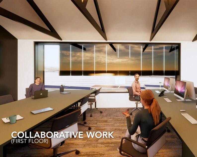 Three people sit at tables with laptops and desktop monitors in a modern office space labeled Collaborative Work (First Floor) with large windows showing a sunset.