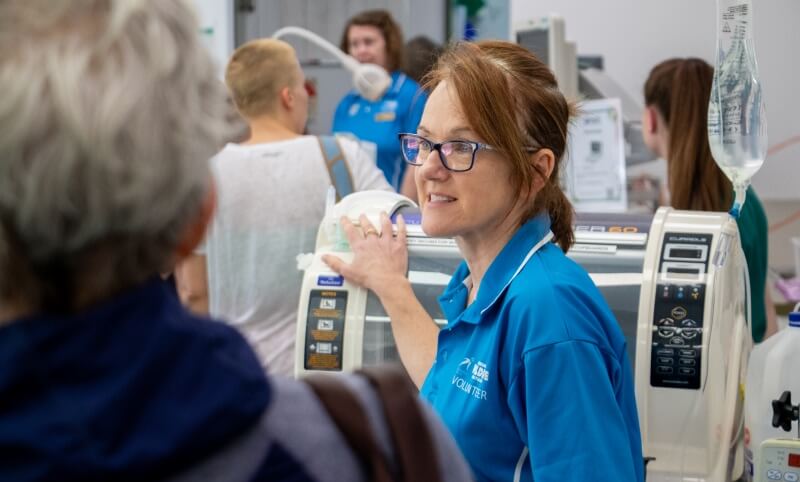 Healthcare worker interacting with medical equipment and patients.