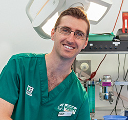 Male smiling wildlife vet in wildlife hospital in front of medical devices